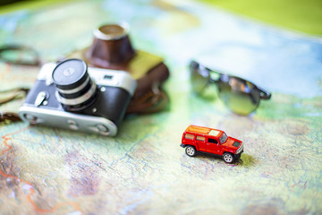 Fototapeta premium Car, glasses and camera on the world map