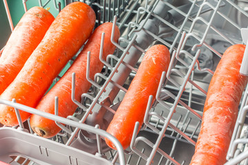 Long carrots lie in the dishwasher