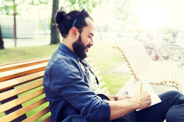 lifestyle, creativity, freelance, inspiration and people concept - creative man with notebook or...