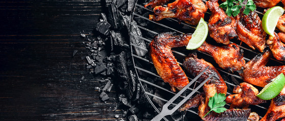 chicken wings of barbecue in honey sauce with lime slices. the dish is made and served in a rustic style