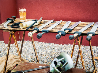 Table full of replica Roman gladiator swords and a helmut from Segedunum, Wallsend, Tyne and Wear