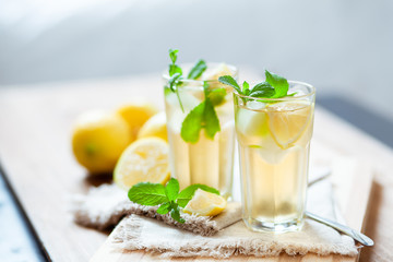 Refreshing summer drink with lemon, mint and ice copy space - obrazy, fototapety, plakaty