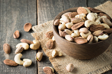 Healthy mix nuts on wooden background. Almonds, hazelnuts, cashews, peanuts, pistachios, brazilian nuts
