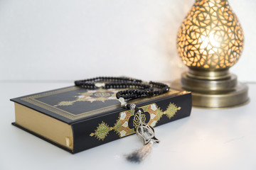 Three months.Islamic Holy Book Quran with rosary beads under soft light on White Background. Ramadan concept .
