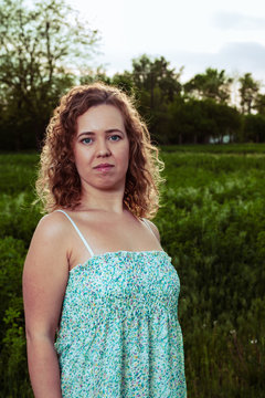 Portrait of a beautiful woman near the field on a farm.