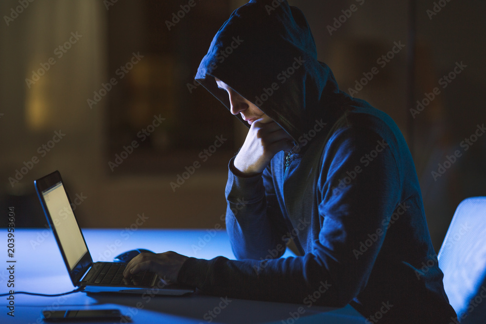 Aufkleber cybercrime, hacking and technology crime - male hacker in dark room using laptop computer for cyber 