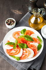 Close-up photo of caprese salad with ripe tomatoes, basil, buffalo mozzarella cheese. Italian and Mediterranean food concept. Fresh and healthy organic meal. Starter and antipasti. 