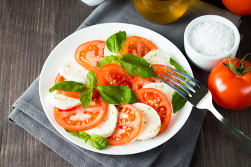 Close-up photo of caprese salad with ripe tomatoes, basil, buffalo mozzarella cheese. Italian and Mediterranean food concept. Fresh and healthy organic meal. Starter and antipasti. 