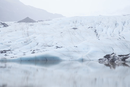 Beautiful silent landscape of glacier Sólheimajökull with tranquil water and misty air, Iceland.  