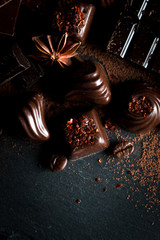 Assortment of dark, white and milk chocolate stack, chips. Chocolate and coffee beans on rustic wooden sacking background. Spices, cinnamon. Selective macro focus. Chocolates background. Sweets