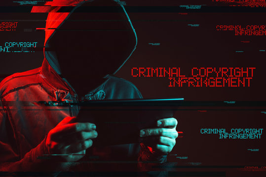Criminal copyright infringement concept with faceless hooded male