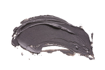 Black clay facial mask smear on white isolated background