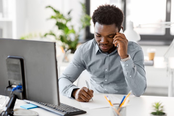 business, people, communication and technology concept - african american businessman with papers...