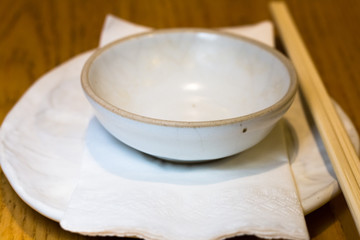 White dish ,chopsticks isolated on wood background.Closed up