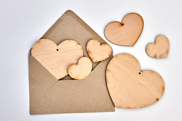 Obraz premium Opened envelope and plywood hearts. Vintage style envelope and wooden hearts on white background. Happy Valentines Day.