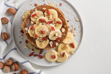 Pancakes with banana, walnuts, goji and honey