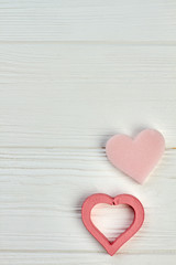 Happy Valentine Day concept on wooden background. Two pink hearts on light wood with copy space. Love and romance concept.