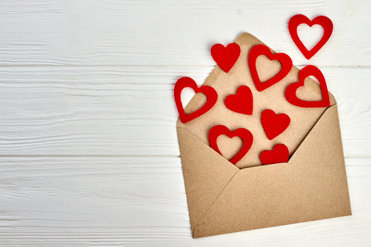 Happy Valentines Day wooden background. Valentines Day envelope and red paper hearts, copy space. Happy Valentines holidays.