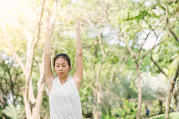 Young asian woman yoga outdoors keep calm and meditates while practicing yoga to explore the inner peace. Yoga and meditation have good benefits for health. Yoga Sport and Healthy lifestyle concept.
