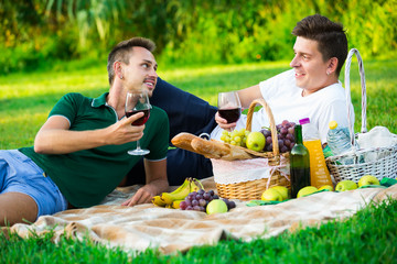 guy with friend drinking wine on picnic