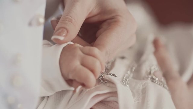 Newborn holding mother's hand. Close up in slow motion. Family concept