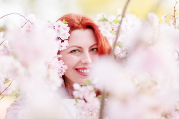 Obraz na płótnie Canvas beautiful woman between almond blossoms