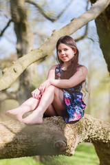 young girl sitting in a tree