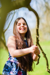 portrait of a young girl playing in a tree