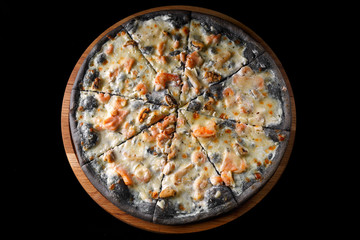 Black pizza on a wooden board