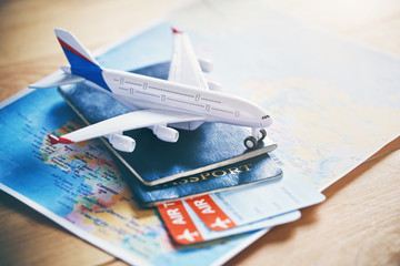 Naklejka premium Model samolotu z mapą świata, paszportami i biletami jako koncepcją podróży samolotem i rezerwacji biletów