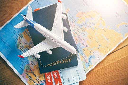 Plane Model With World Map, Passports And Tickets As Airplane Traveling And Tickets Booking Concept