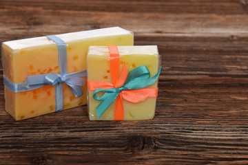 two soaps with pieces of citrus fruit homemade for her and for him wrapped with a bow with free space for text