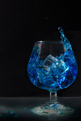 splash of water in a glass with ice on a black background