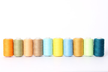 sewing thread of different colors isolated on white.