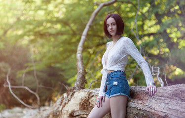 Sexy hippie girl in ornaments boho chic stands near a huge tree