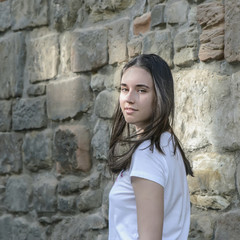 Young beautiful dark-haired girl model appearance in an old town in the spring.