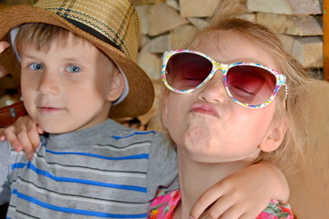 A girl with glasses beside a boy kisses