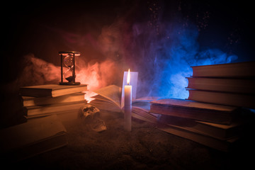 Wizard's Desk. A desk lit by candle light. A human skull, old books on sand surface. Halloween...