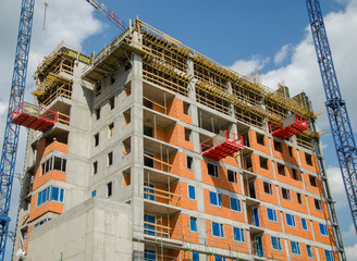 High rise building under construction. big building construction site and cranes against blue sky...