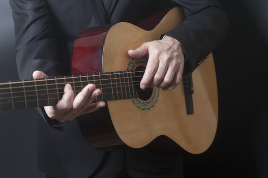 Man in black suit with acoustic classic guitar