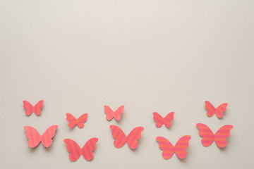 Mariposas rosas de papel sobre una superficie gris
