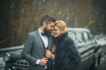Young beautiful couple relaxing together walking at a retro car.