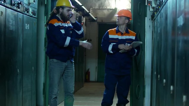Two electricians at the substation. Employees shake hands