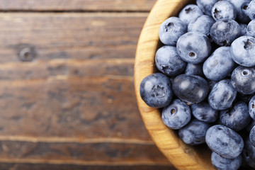 blueberry in a plate on a wooden background