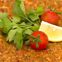 Turkish tortilla pita with minced meat and spices, decorated with cherry tomatoes and parsley leaves.