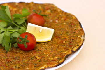 Turkish tortilla pita with minced meat and spices, decorated with cherry tomatoes and parsley leaves.