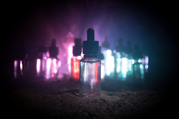 Vape concept. Smoke clouds and vape liquid bottles on dark background. Light effects. Useful as...