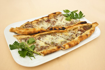 Turkish tortilla pita with pieces of meat, melted cheese and slices of vegetables