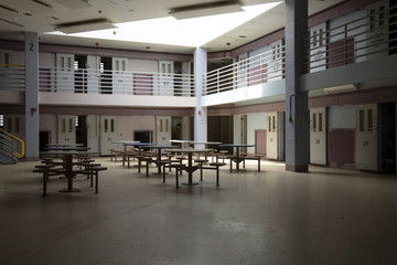 Abandoned jail common room in cell block - obrazy, fototapety, plakaty