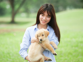 Asian woman playing puppy dog in park